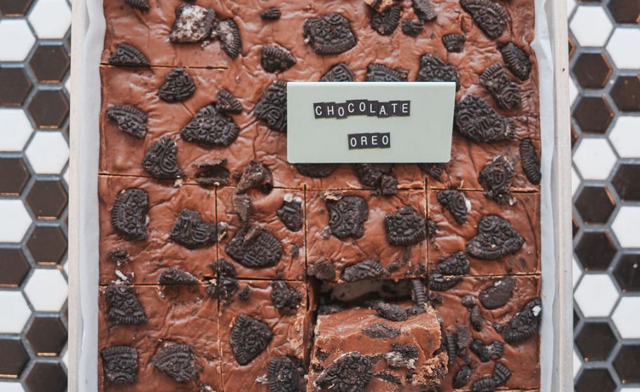 Tray of chocolate Oreo fudge squares topped with crushed cookie pieces.