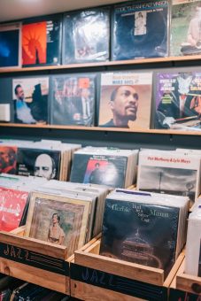 Jazz vinyl records displayed in wooden bins inside a music shop.