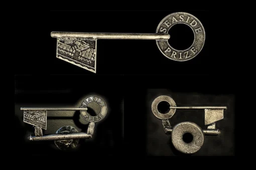 Three metallic keys featuring "Seaside Prize" inscription, each shown from different angles, set against black background.