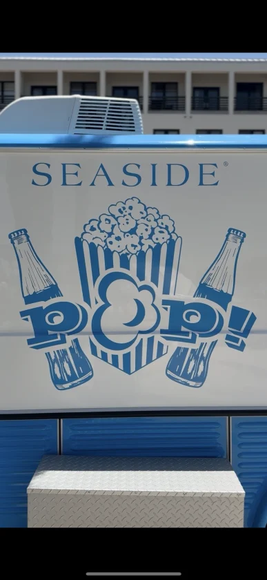 Illustrated “Seaside Pop!” graphic with popcorn bucket and soda bottles on a food truck side.