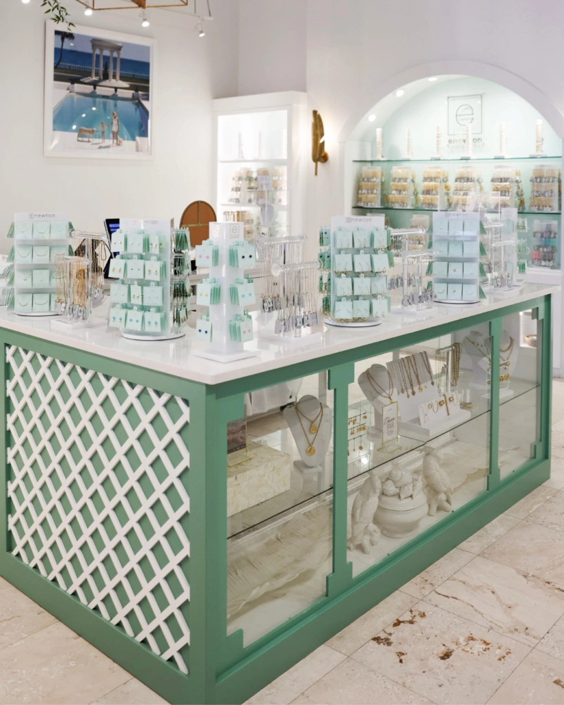 Bright, stylish jewelry boutique with mint-green display counter, white lattice detailing, and neatly arranged accessories.