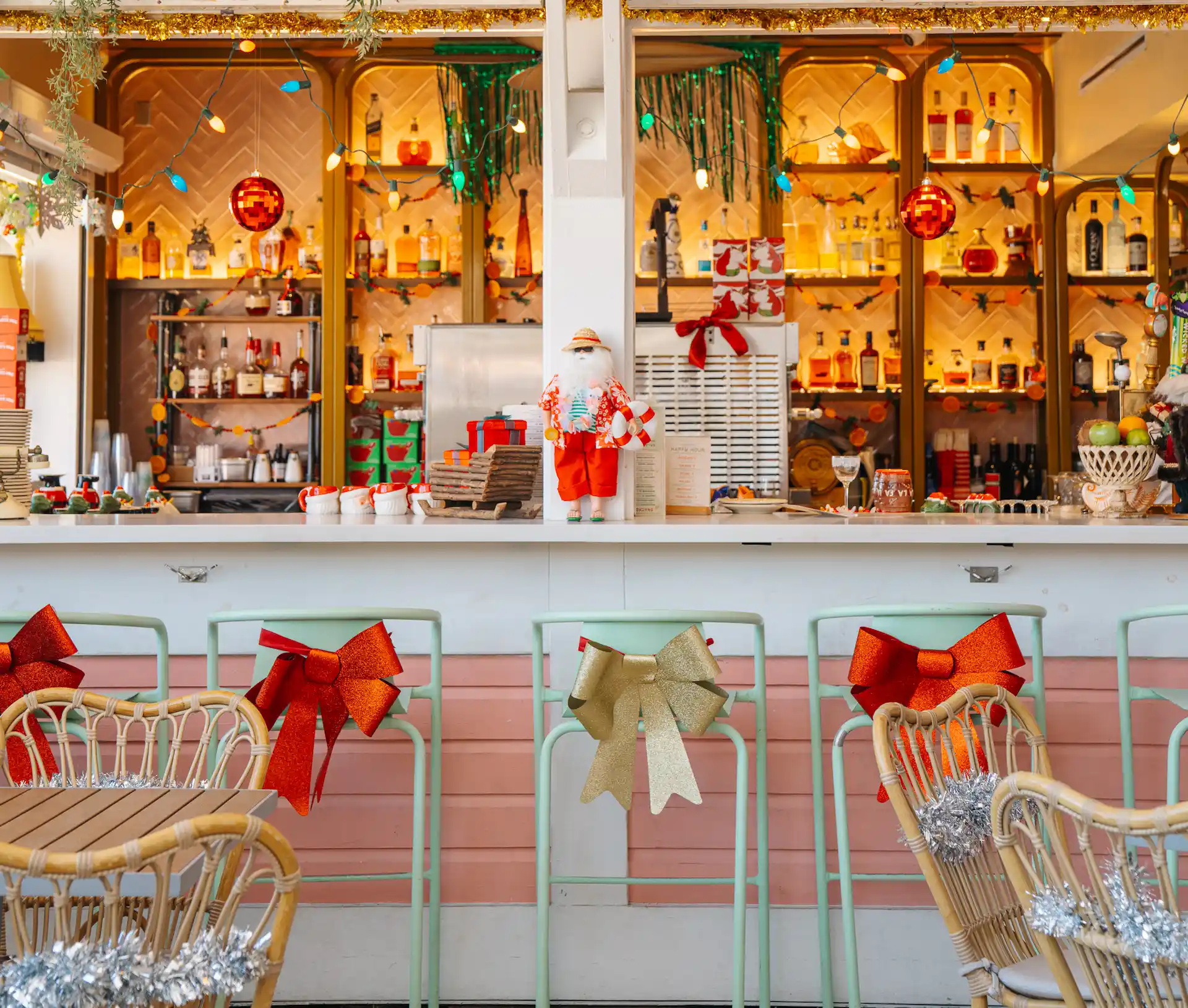 Festively decorated beach bar with colorful lights, bows, and tropical Santa figurine.