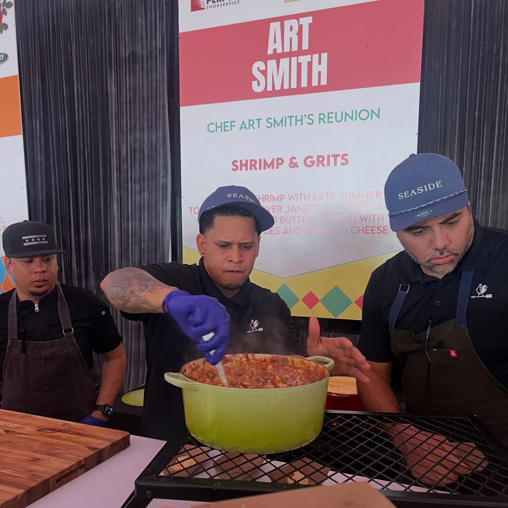 Chefs preparing shrimp and grits at Chef Art Smith’s Reunion food booth.