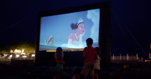 Families gathered on the lawn at the SEASIDE® Amphitheater for outdoor movies in summer